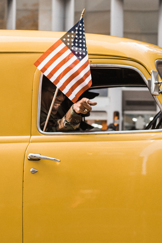 Army veteran participating in America's Parade from the passenger seat of an American classic car on November 11, 2015. ©Leda Costa